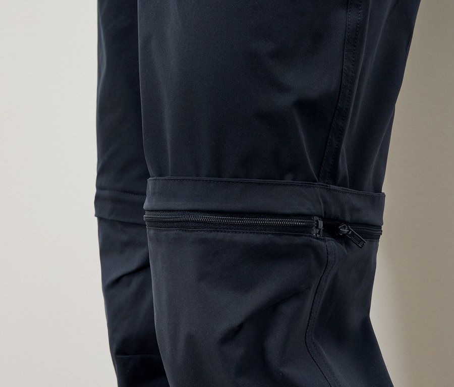 Detail modrých nohavíc s vreckom na zips na nohe.