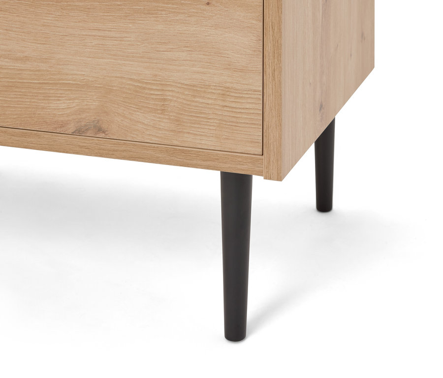 Detailný záber na svetlohnedú drevenú skrinku s čiernymi nožičkami.