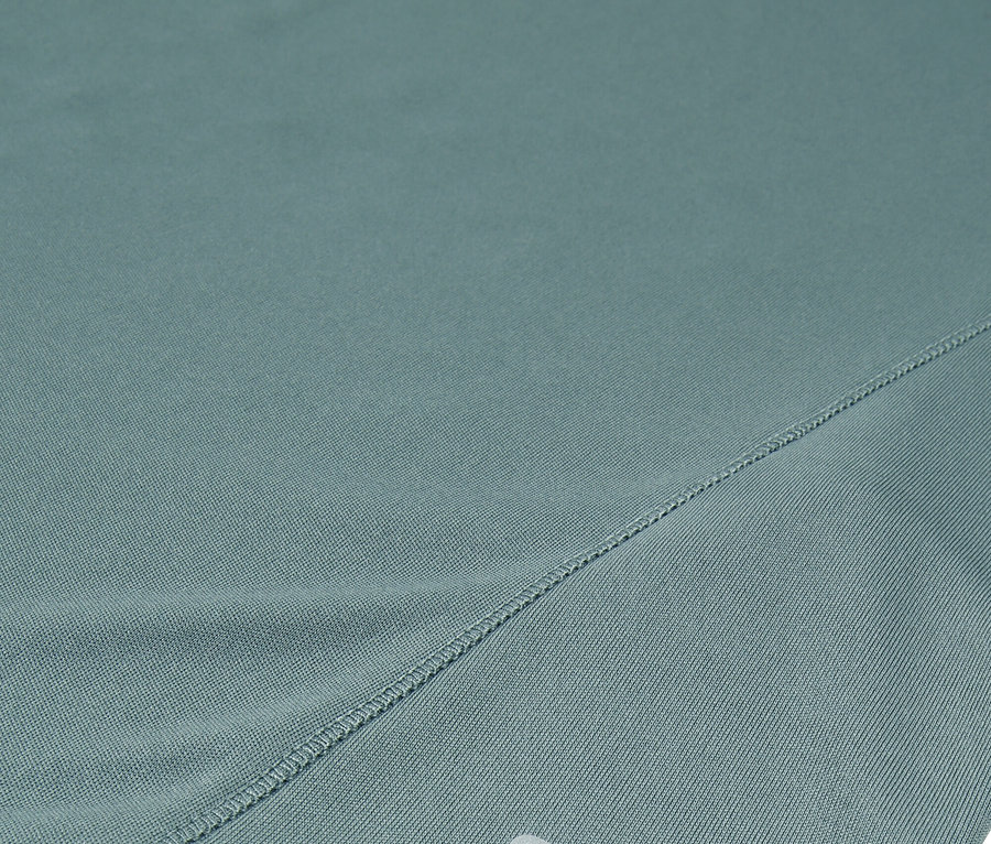 Detailný záber tyrkysových šortiek Fila so strieborným logom.