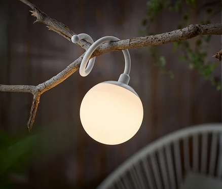 Biela guľovitá lampa visí na konári.