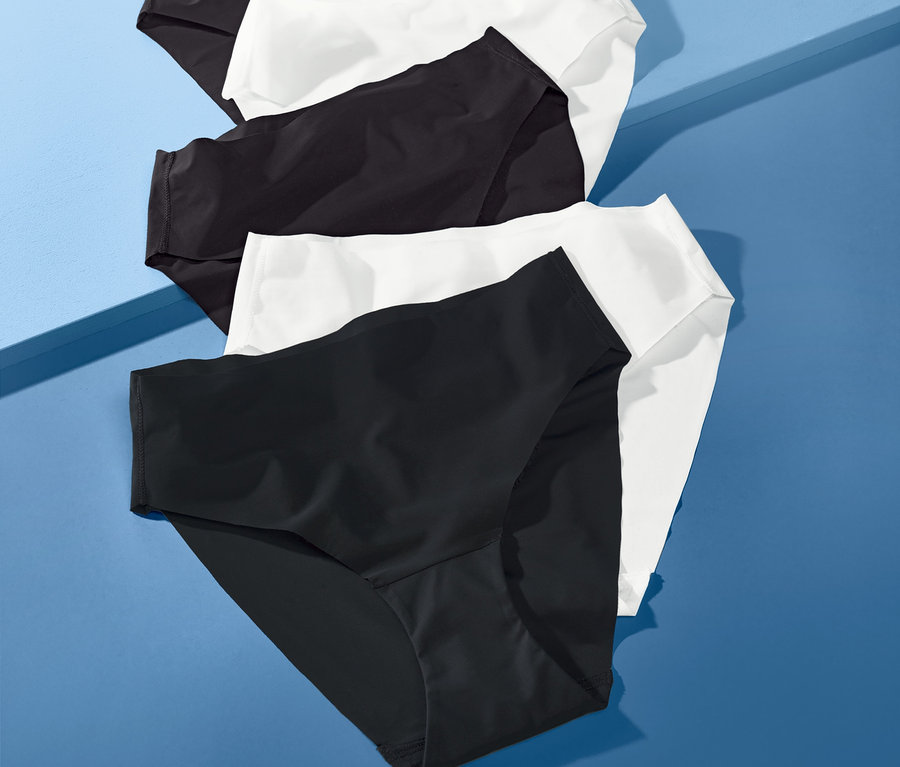 Päť kusov nohavičiek »Magic Cut« v čiernej a bielej farbe leží na modrom pozadí.