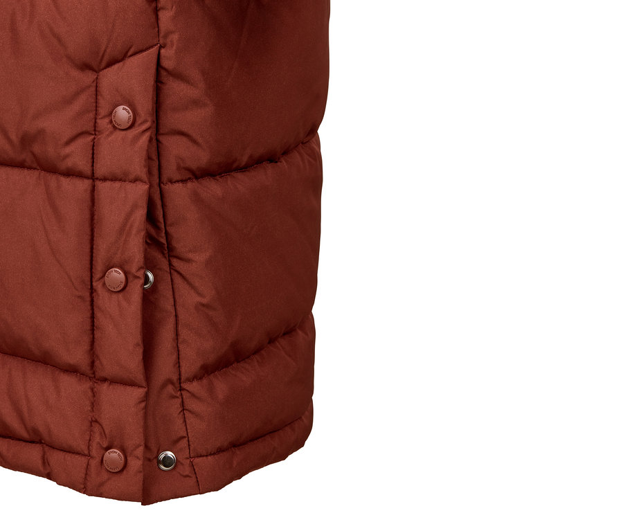 Detail hnedej prešívanej bundy s kapucňou a patentkami.