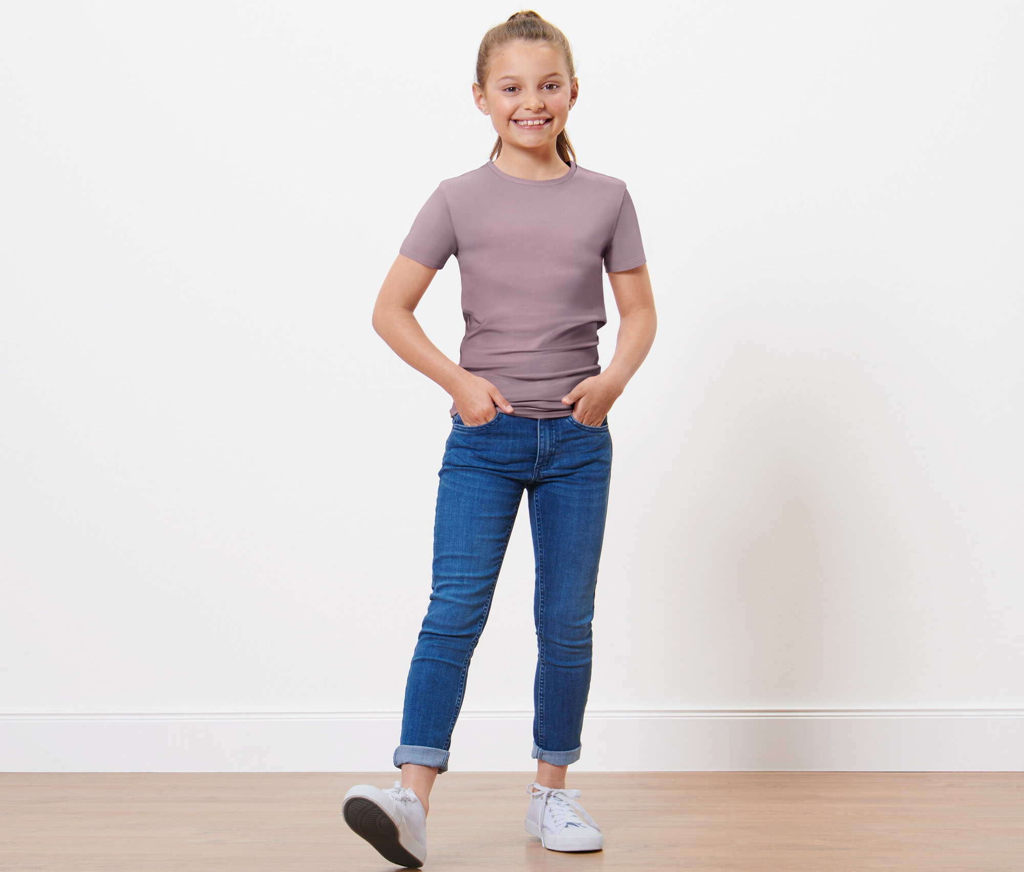 Dievča stojí a pózuje v detskom tričku, 3 ks.