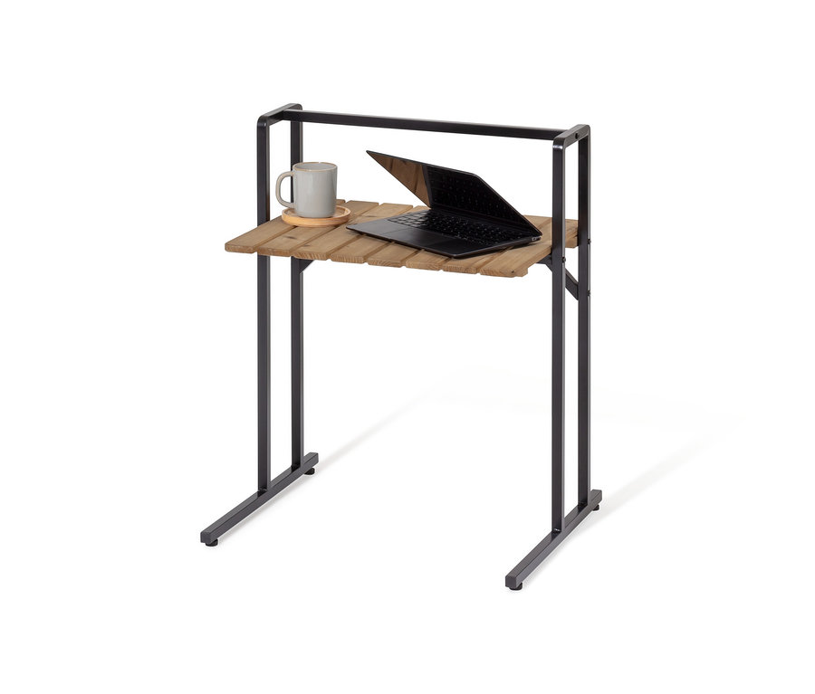 Na C-stole s veľkou stolovou doskou leží sivý hrnček a otvorený notebook.