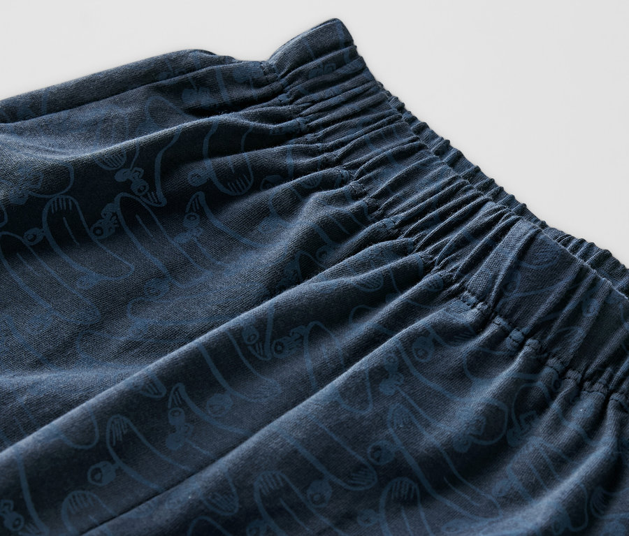 Detail krátkeho detského pyžama s elastickým pásom a potlačou.