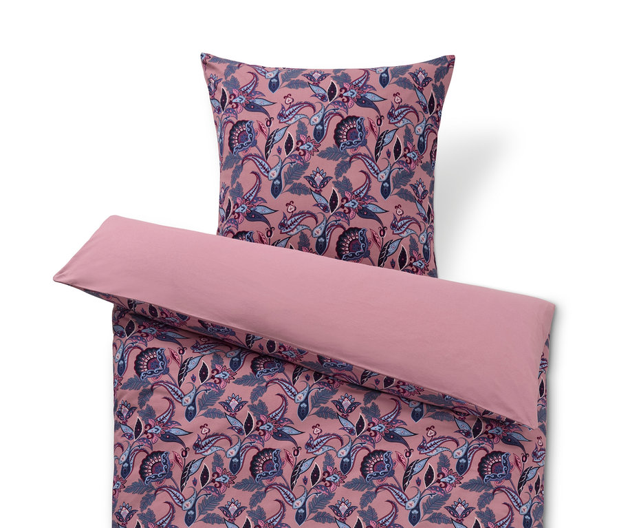 Ružové obliečky zo zimného džerseja s kvetinovým vzorom a vankúš navrchu.