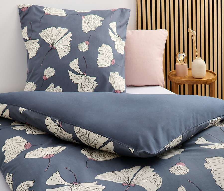 Detailný záber na tmavomodrú posteľnú bielizeň z mikrovlákna s kvetinovým vzorom v štandardnej a nadrozmernej veľkosti.