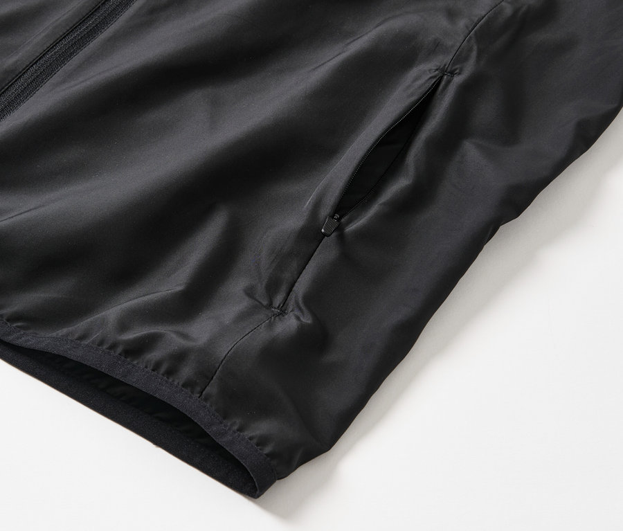 Detailný záber na čiernu funkčnú vestu.