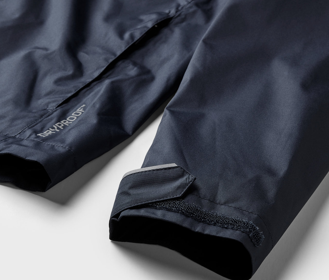 Detail námorníckej modrej bundy do dažďa.