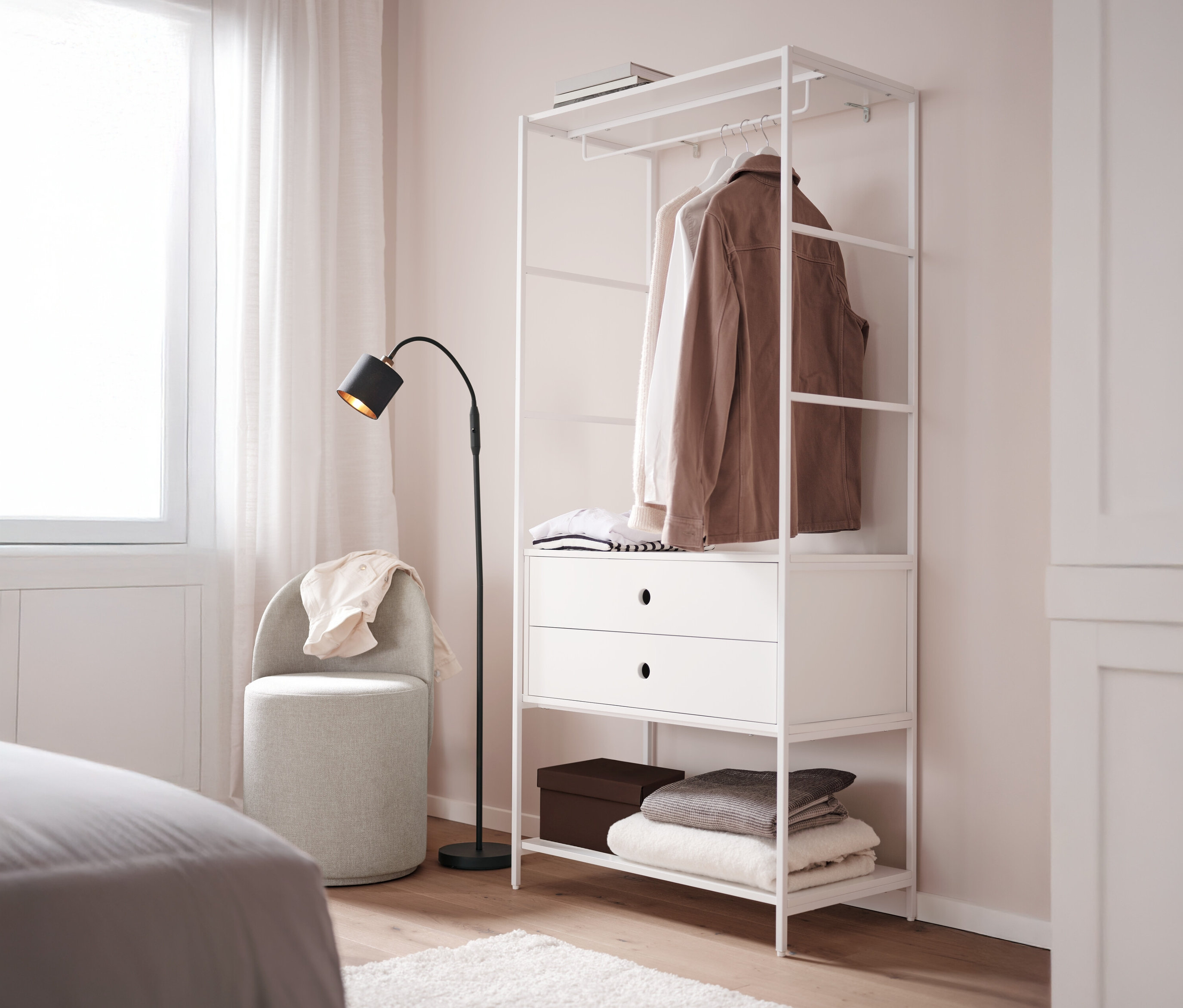 Otočná taburetka s chrbtovou opierkou stojí vedľa bielej vešiakovej steny »KLAAR« s 2 zásuvkami v spálni.