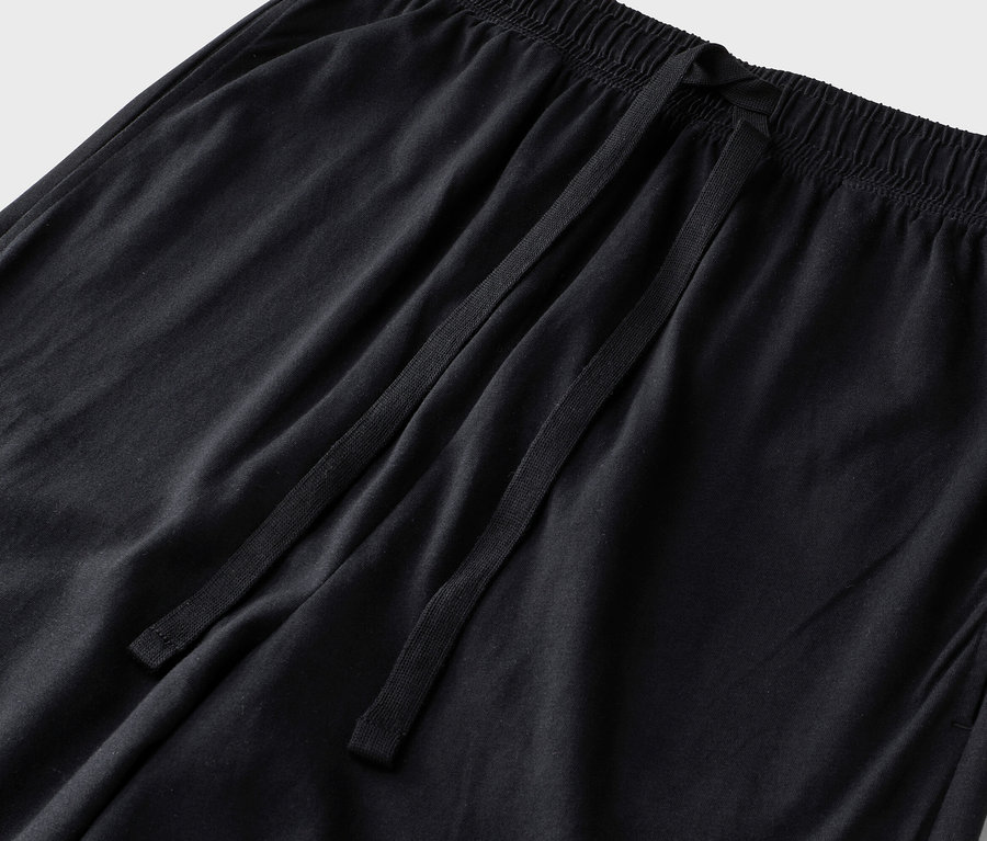 Detail čiernych nohavíc so šnúrkou a elastickým pásom.