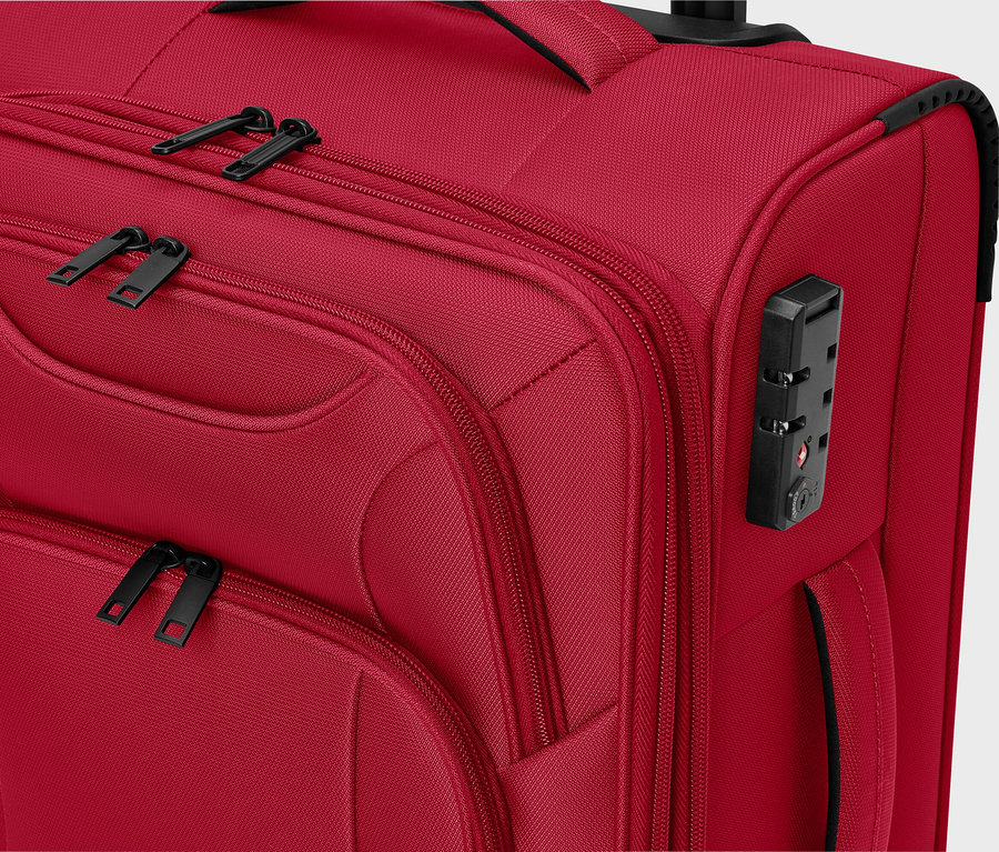 Detailný pohľad na červený látkový kufor s čiernymi zipsami a číselným zámkom.