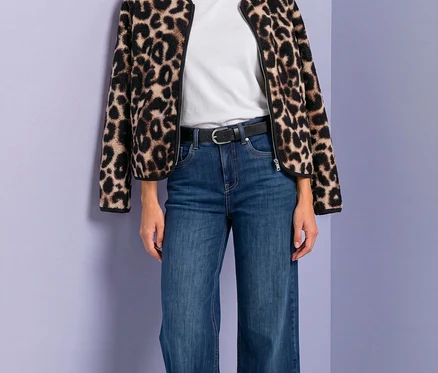 Žena v bunde Street One s leopardím vzorom, bielom tričku, modrých džínsoch a čiernom opasku.