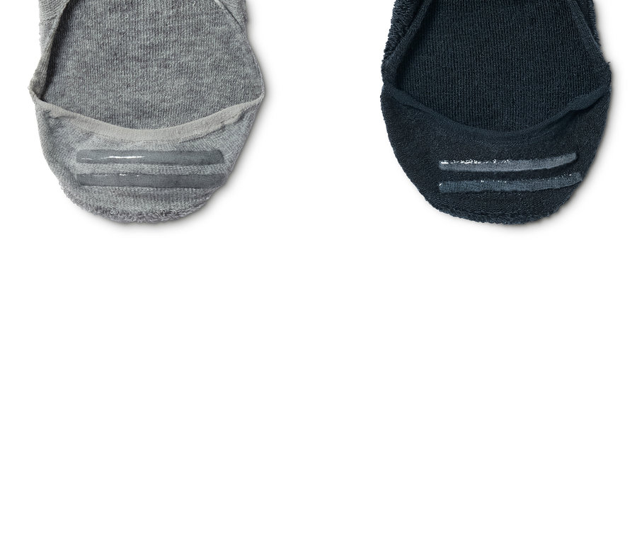 Detail dvoch športových ťapiek, jednej šedej a jednej tmavomodrej.