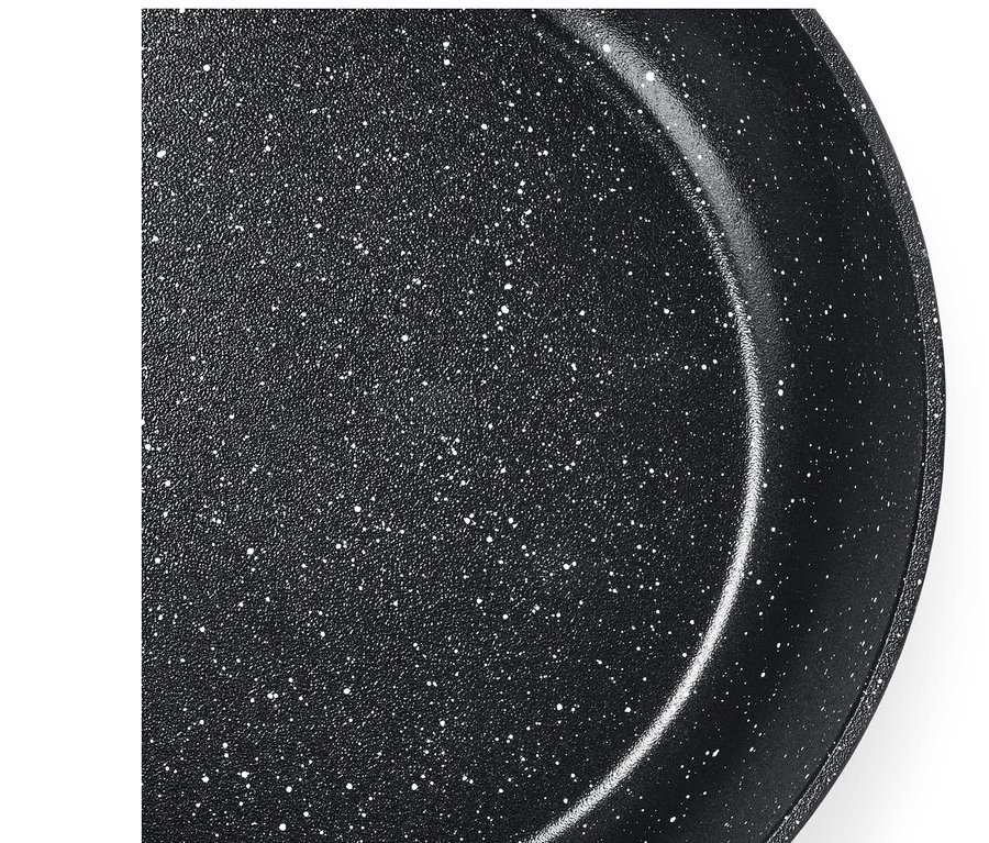 Detailný záber na vnútro čiernej panvice s bielymi škvrnami.