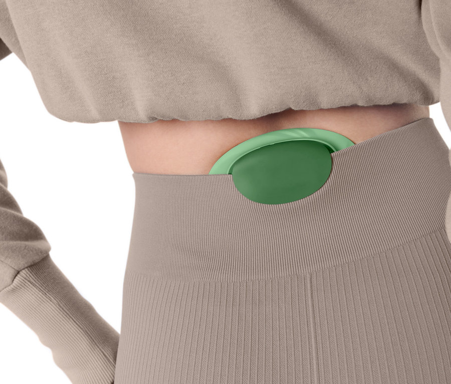 Žena má v nohaviciach zasunutú zelenú masážnu loptičku.