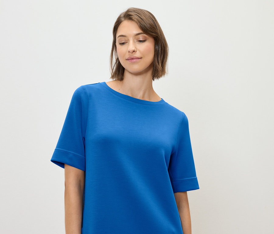 Žena má na sebe modré tričko.