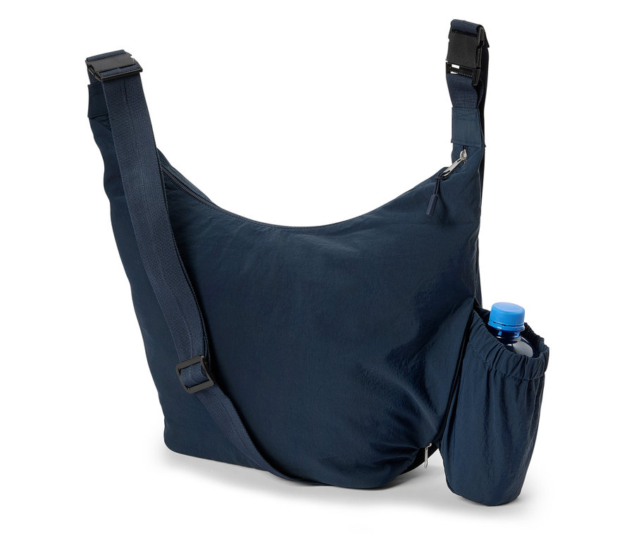Detailný záber na tmavomodrú tašku cez rameno s fľašou vody v bočnom vrecku.