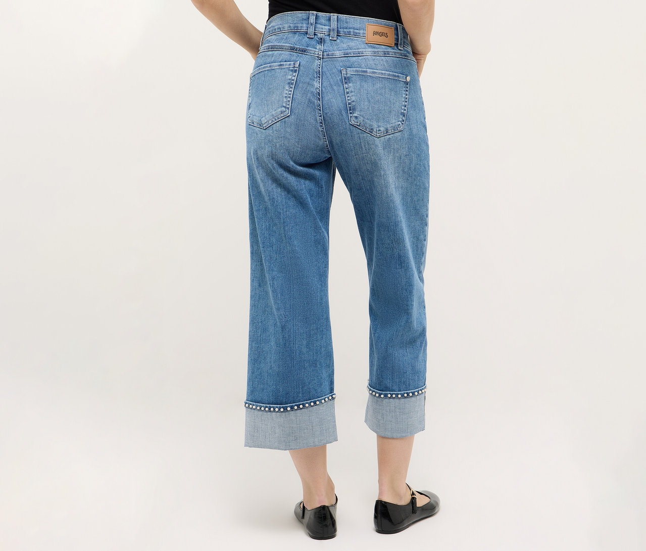 Osoba zozadu nosí Angels Denim »Linn Cool« v kombinácii s čiernymi topánkami na neutrálnom pozadí.