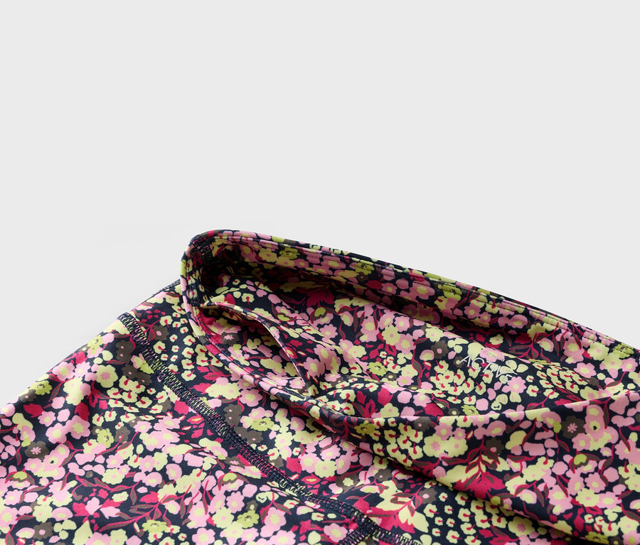 Detail kvetinových legín s tmavomodrým pásom a bočným vreckom.