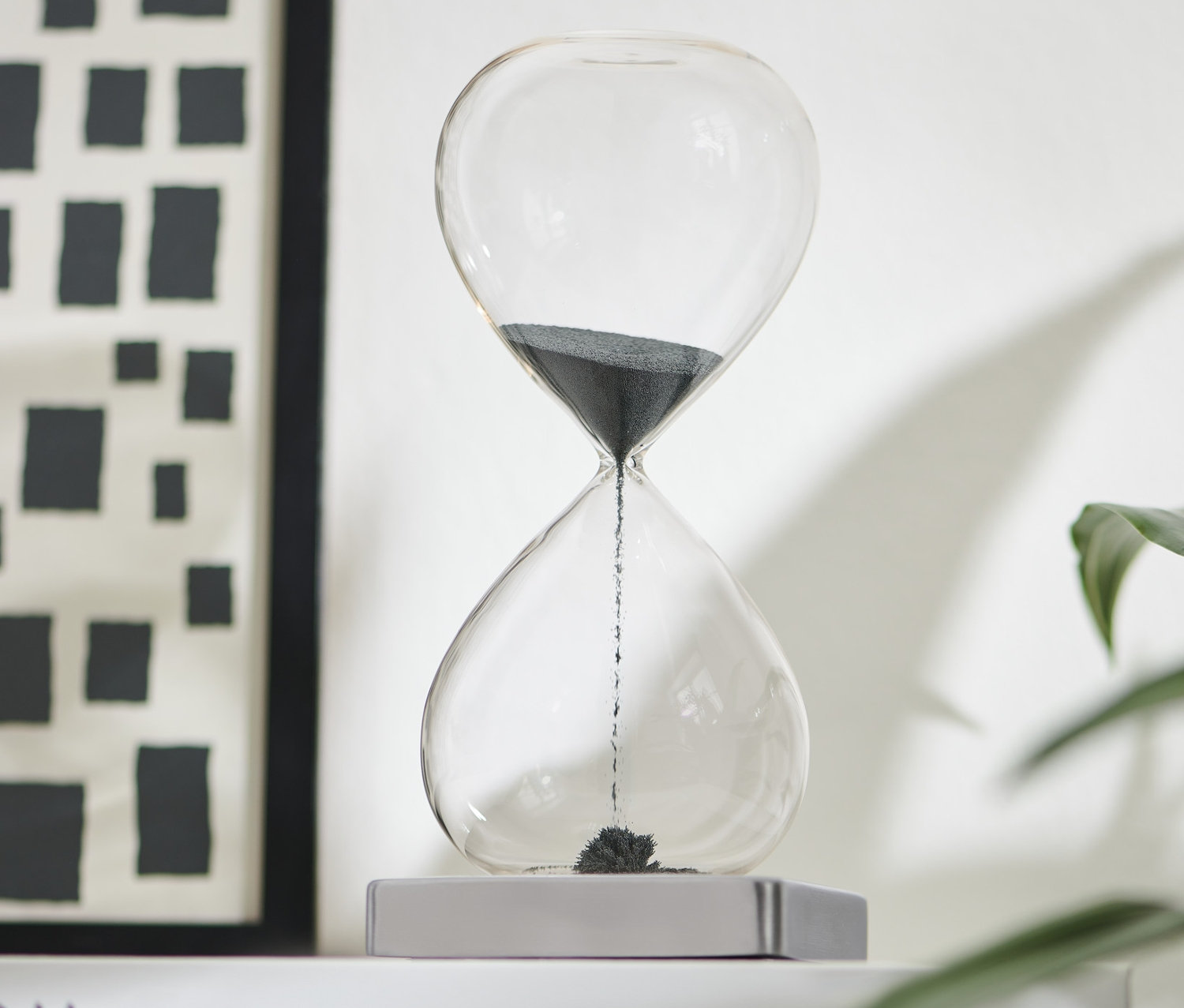 Čierne magnetické presýpacie hodiny na bielej knihe.