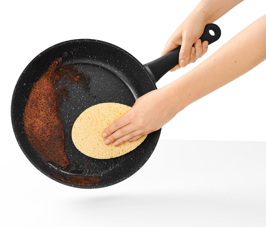 Čistenie panvice s priemerom 28 cm vo vzhľade kameňa pomocou hubky.