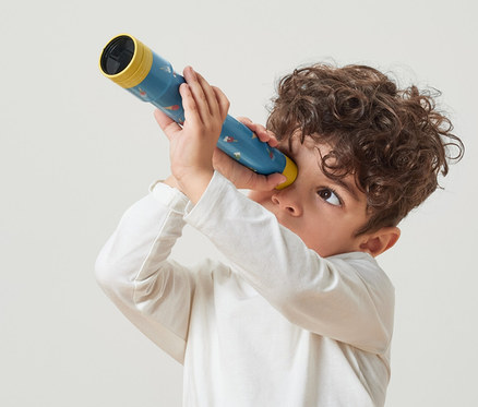 Chlapec sa pozerá cez hračkársky teleskop.