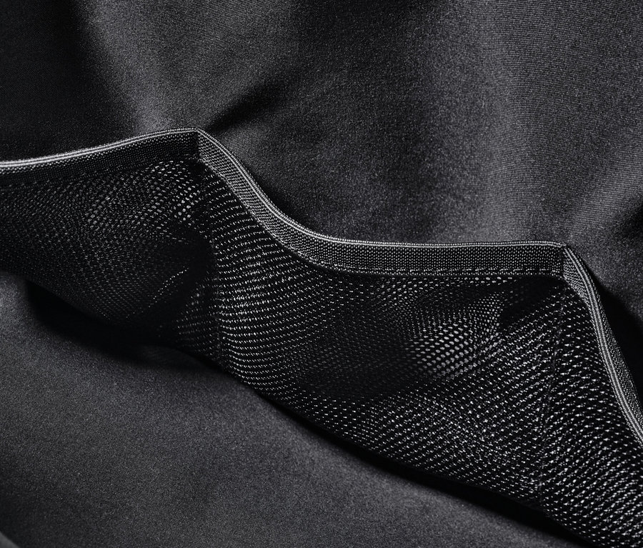 Detail čiernej športovej tašky s vonkajším sieťovaným vreckom.