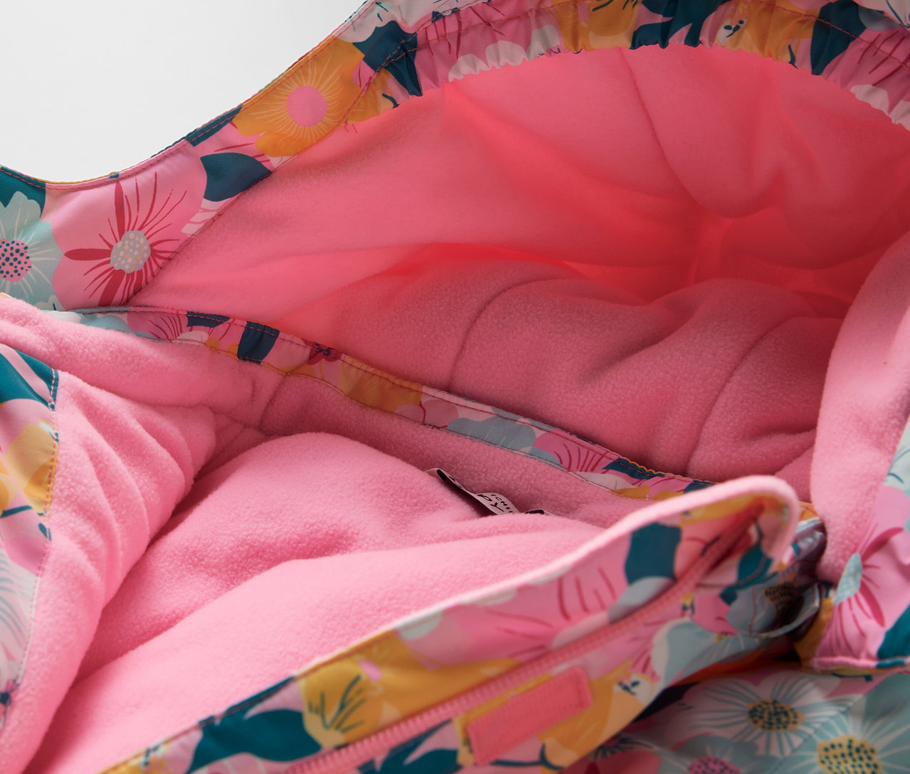 Detail kapucne bundy s kvetinovým vzorom a ružovou podšívkou.