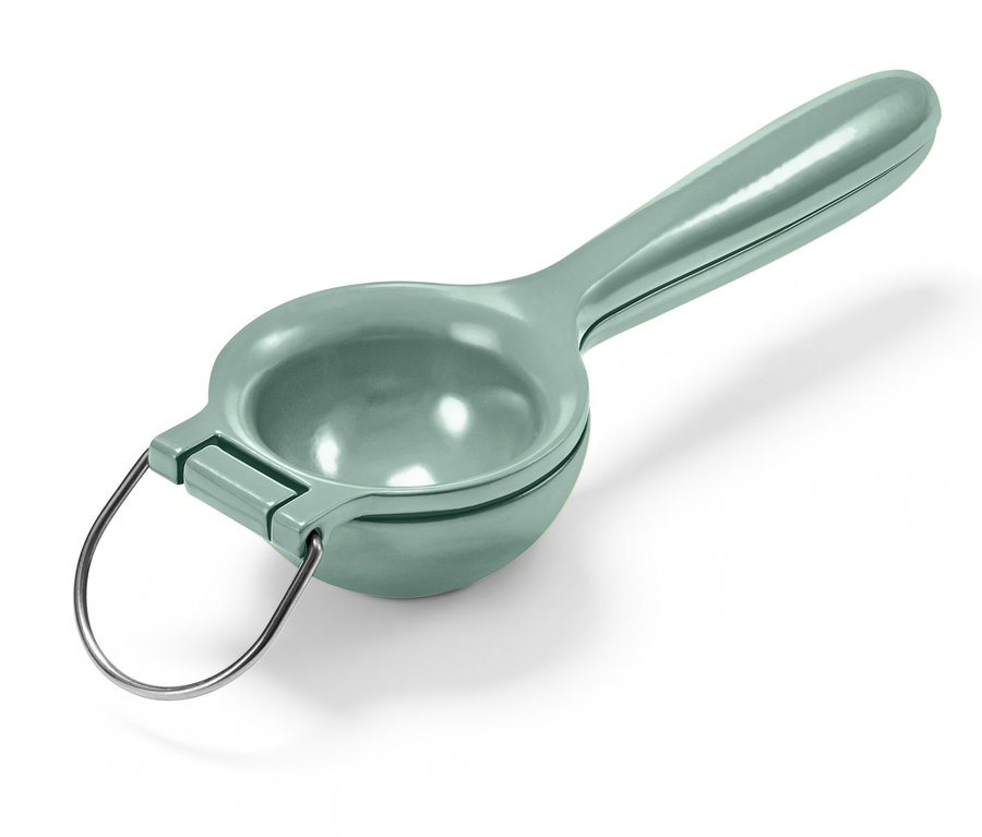 Zelený lis na citrusy s kovovou rukoväťou.