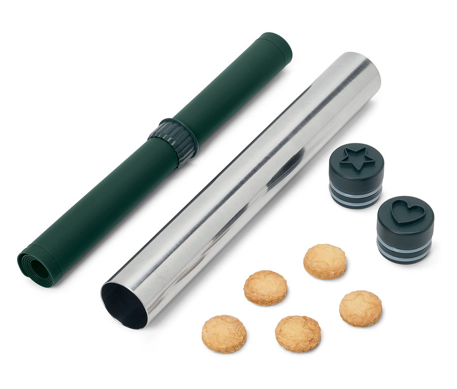 Zelená rolovacia podložka a strieborný valček s vykrajovačkami na sušienky v tvare hviezdy a srdca a sušienkami.