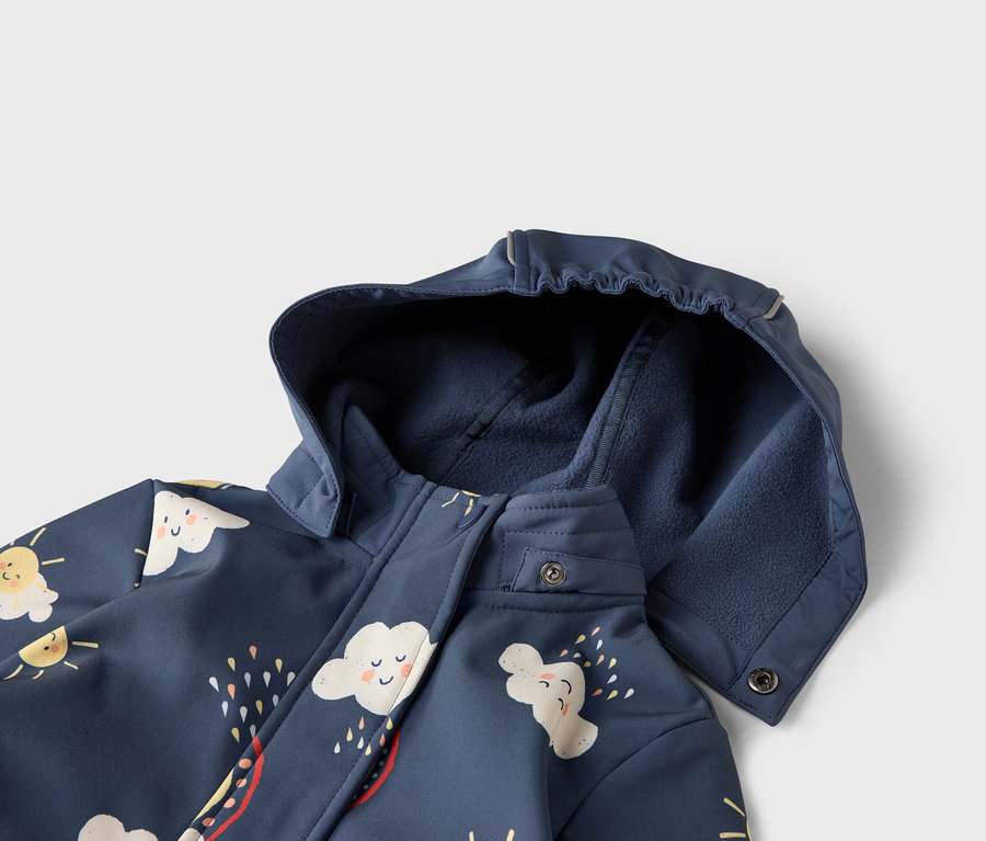Detailný pohľad na tmavomodrú bundu s kapucňou, zdobenú motívmi oblakov a slnka.