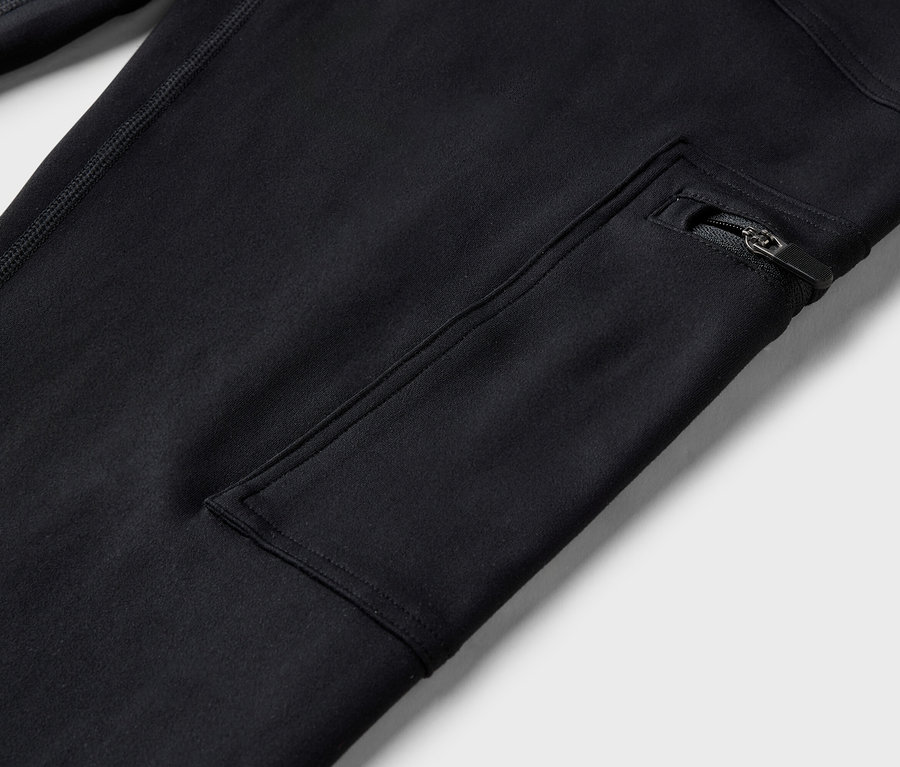 Detailný záber na čierne nohavice s vreckom na zips.