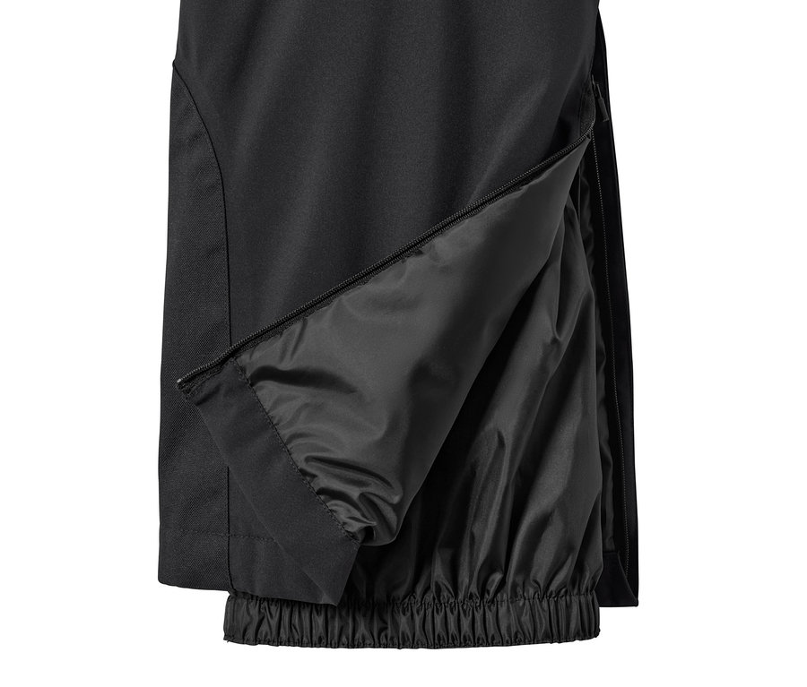 Detail čiernych lyžiarskych nohavíc so zipsom na nohavici.