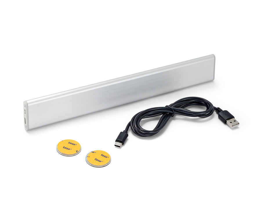 LED multifunkčné svietidlo s akumulátorom, čierny kábel a dve lepiace kolieska na bielom pozadí.