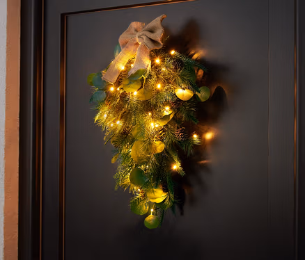 LED dekorácia na dvere visí na čiernych dverách.