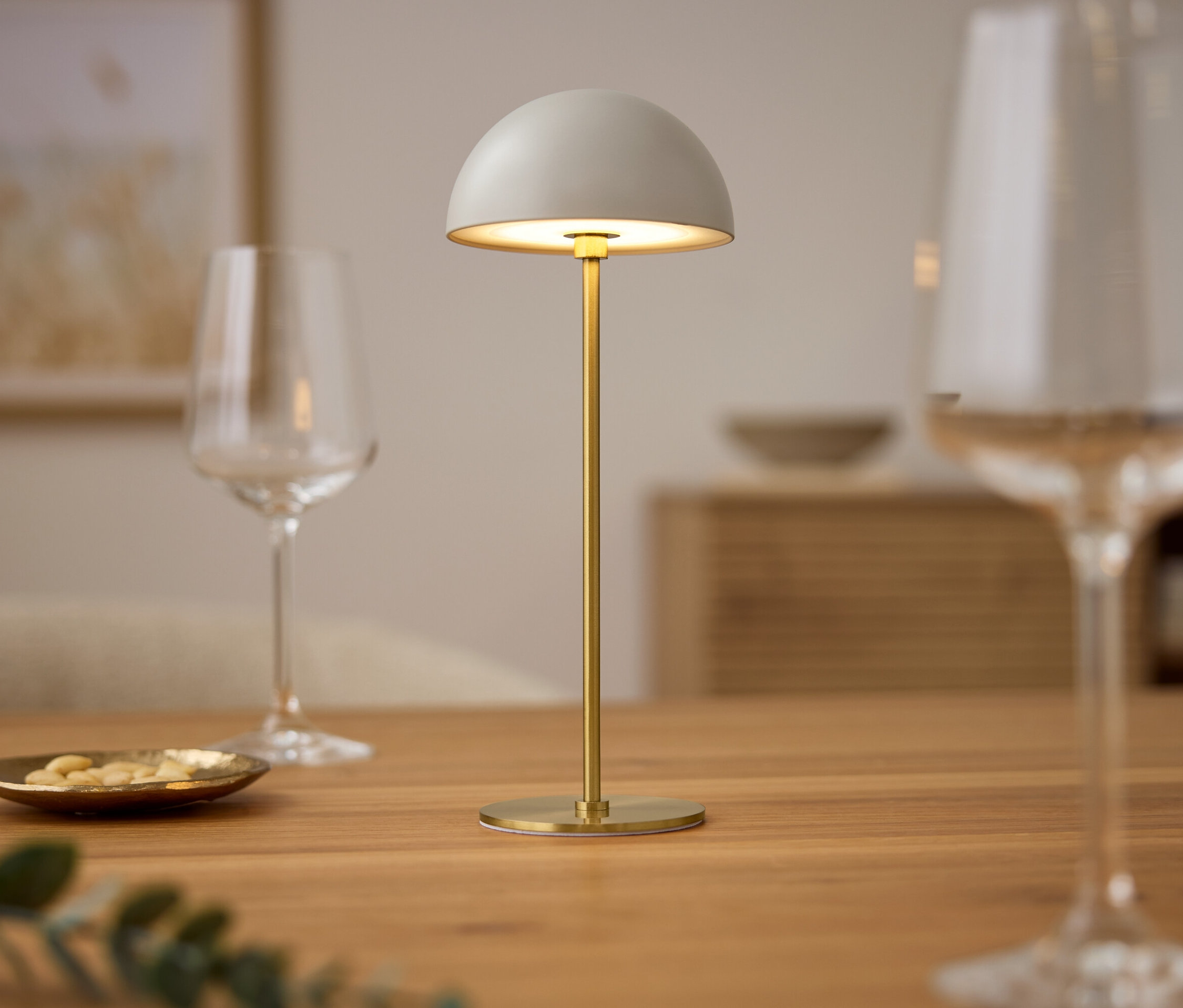 Stolná lampa so sklenenými pohármi na drevenom stole.