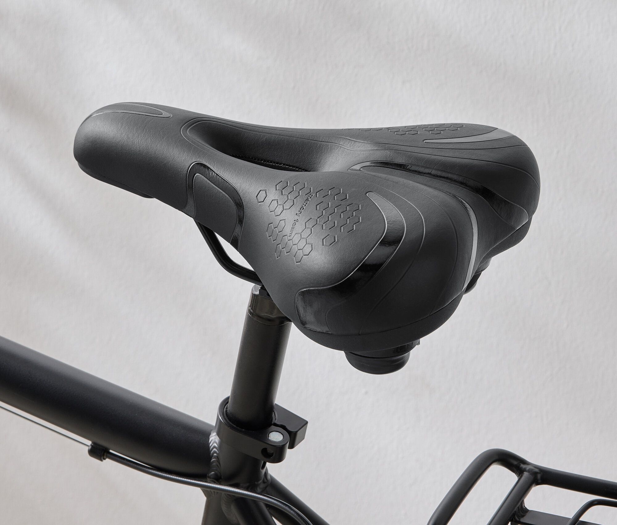 Detailný záber na čierne sedlo bicykla so vzorom šesťuholníkov na sedadle.