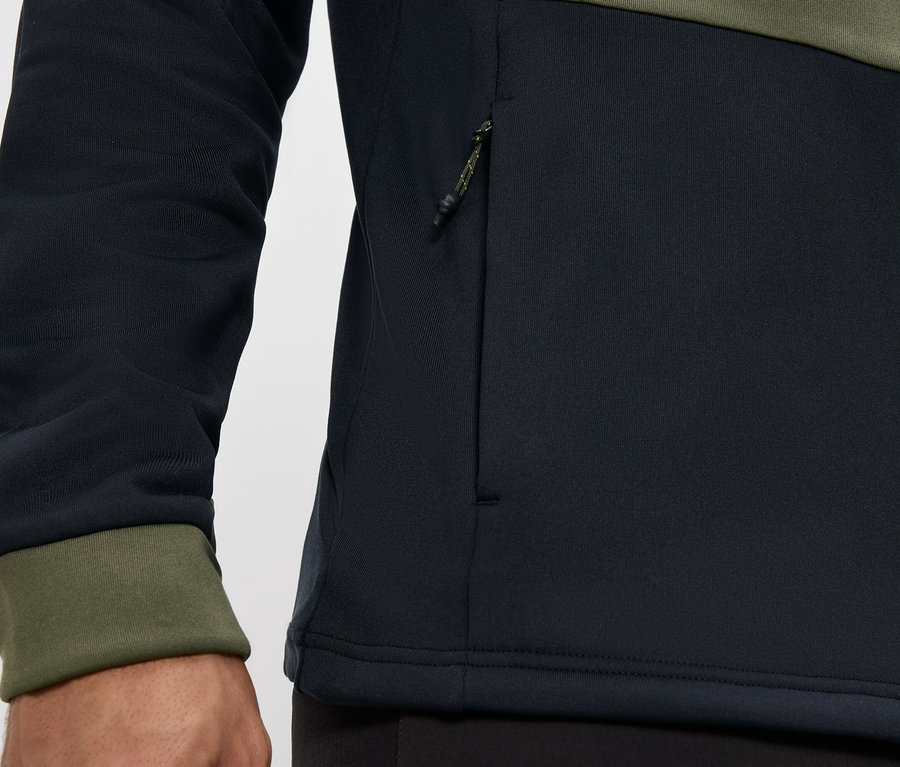 Detailný záber na čiernu a olivovo zelenú bundu so zipsom a vreckom na zips.