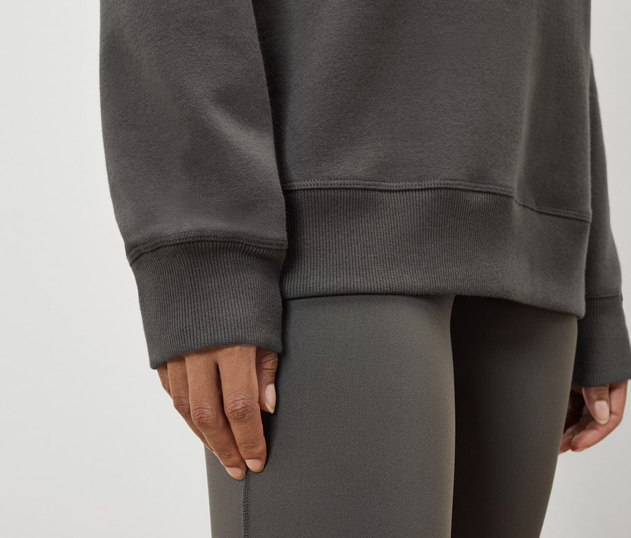 Detail dámskej mikiny a legín v šedej farbe.