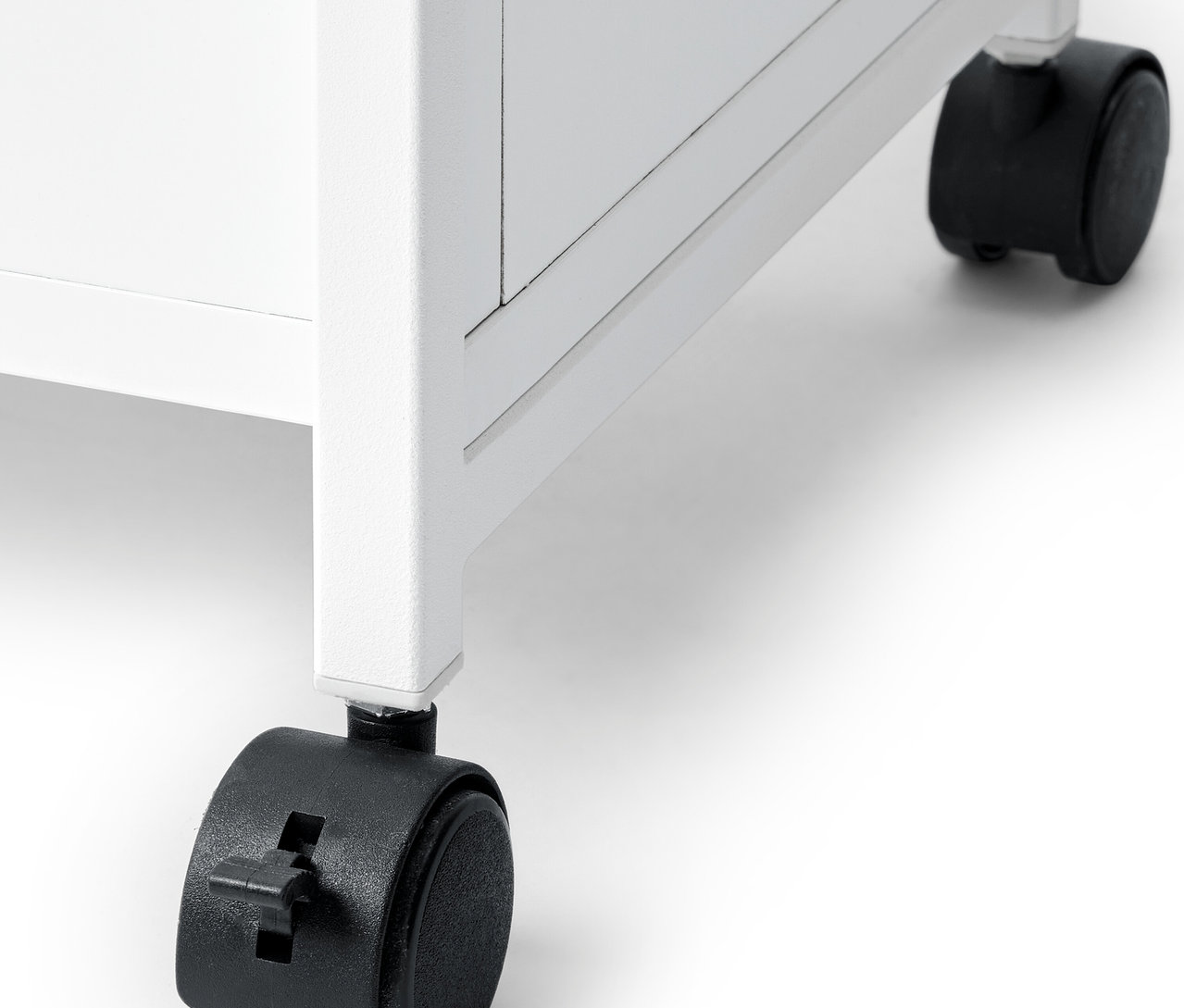Detail bieleho regálu »KLAAR« s čiernymi kolieskami.