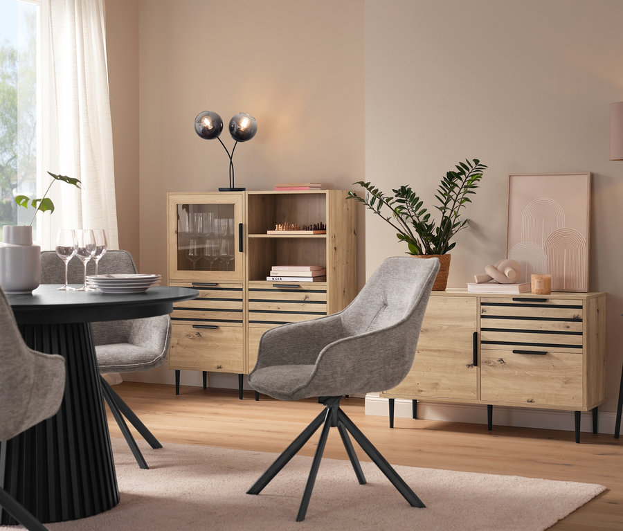 Jedáleň s okrúhlym stolom, sivými stoličkami, vitrínou »BAAKEN« s presklenými dverami, regálom »BAAKEN« so zásuvkami a príborníkom so zásuvkami.