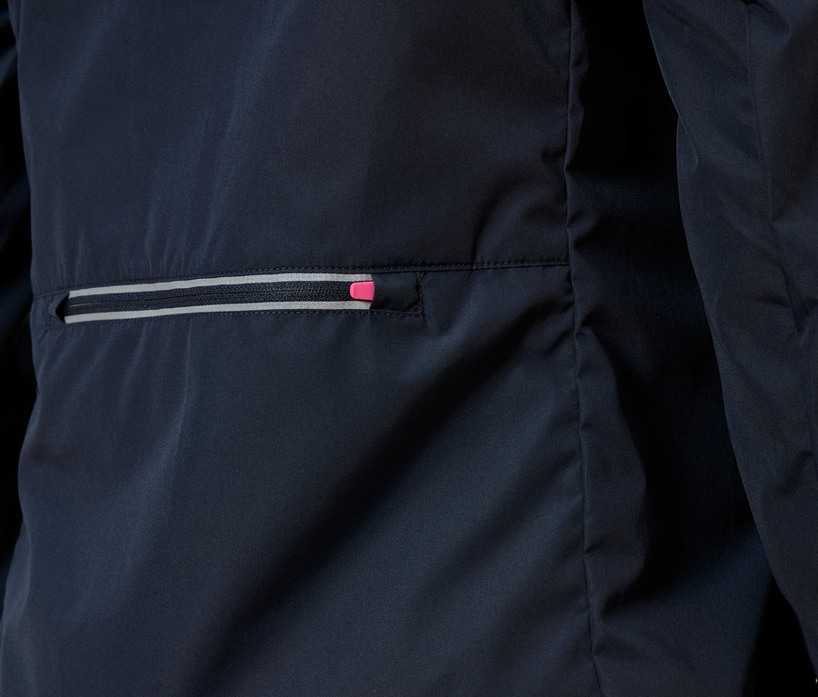 Detailný záber na tmavomodrú bundu s vreckom na zips, ktorého zips má ružový akcent.