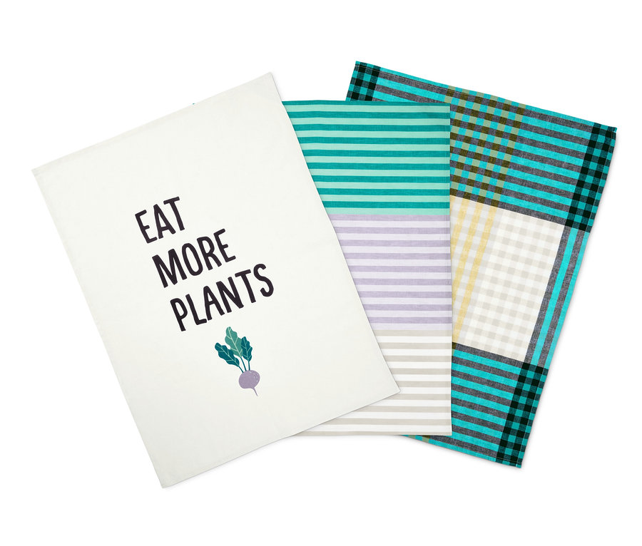 Tri utierky na riad: biela s nápisom "Jedzte viac rastlín", pruhovaná a kockovaná.