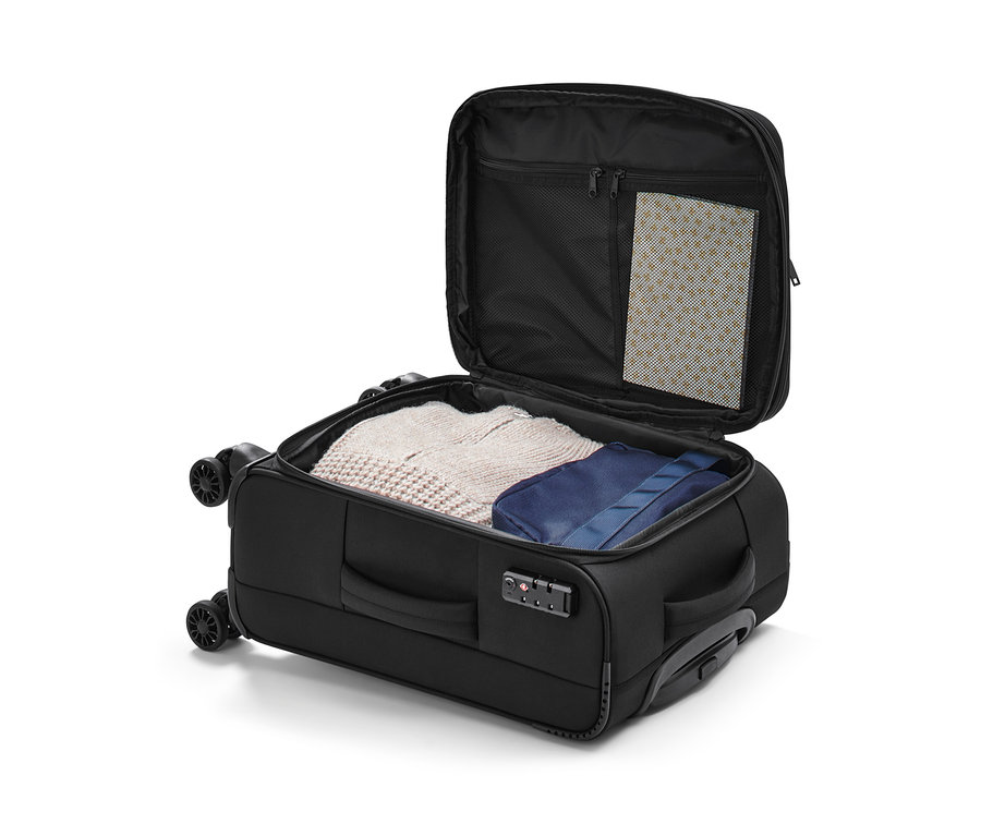 Otvorený textilný kufor, malý, s oblečením vnútri.