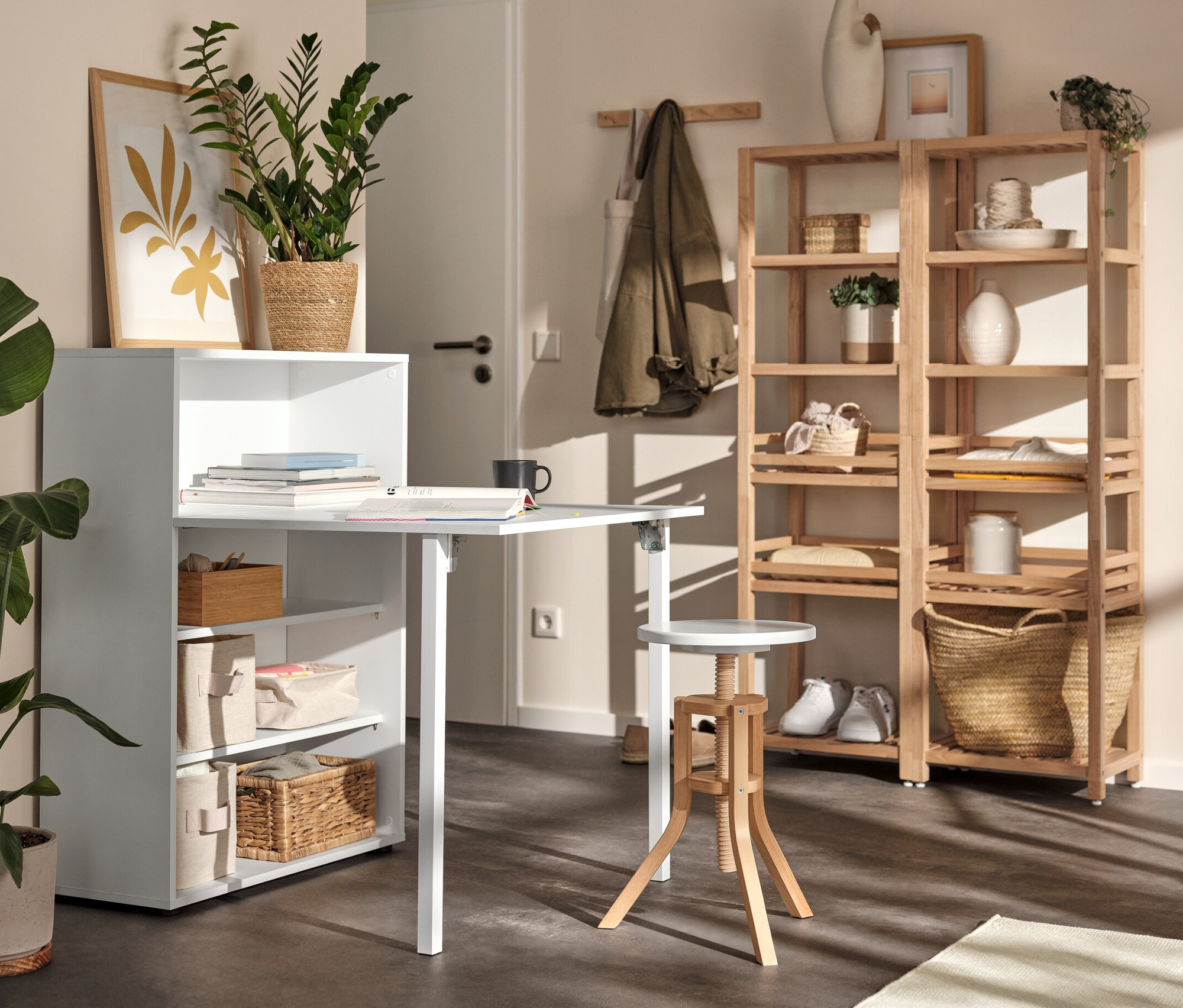 Biely regál s výklopným stolom, drevený regál a vretenová taburetka v interiéri.