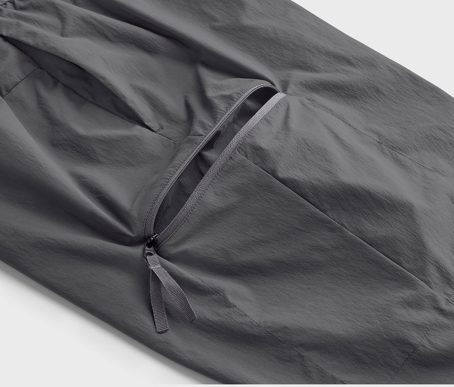 Detail sivých ľahkých funkčných nohavíc s vreckom na zips.