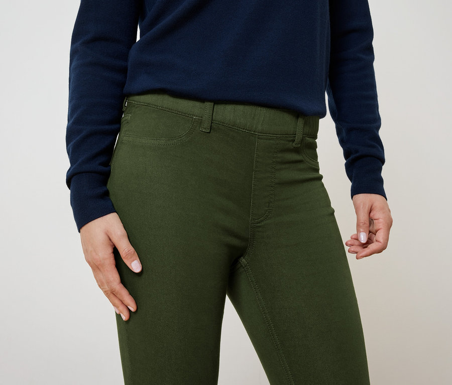 Detail dámskych olivovo zelených nohavíc a tmavomodrého svetra.