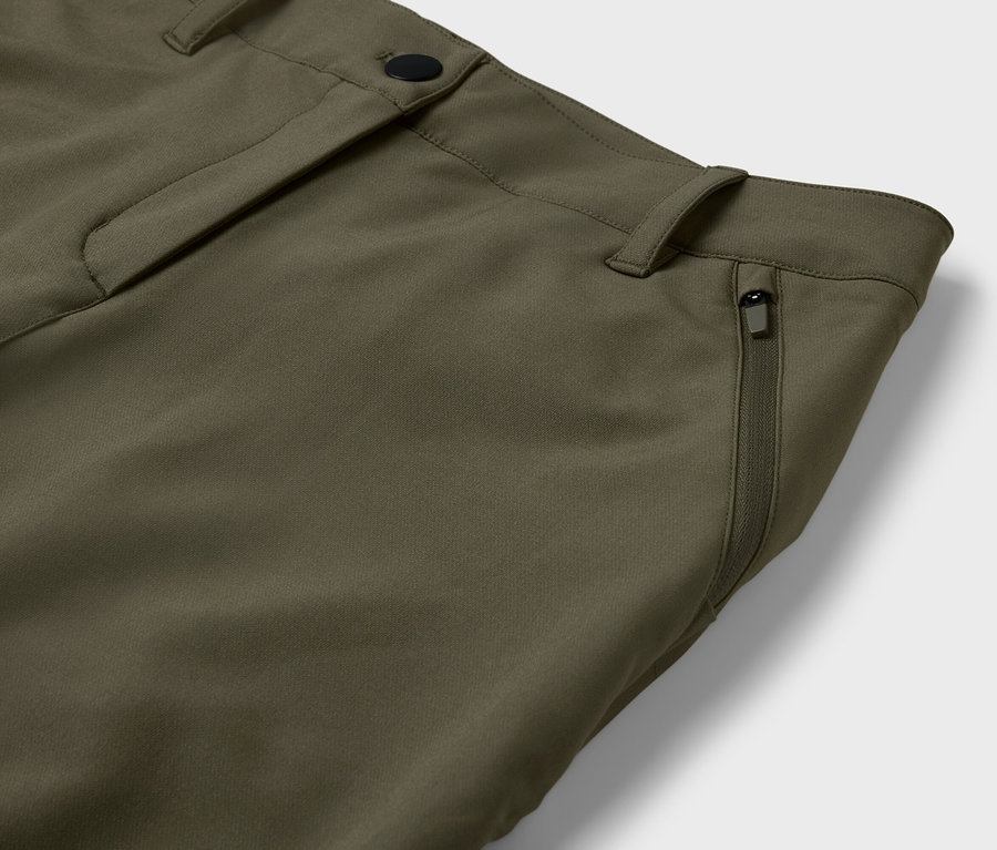 Detail olivovo zelených nohavíc s vreckom na zips.