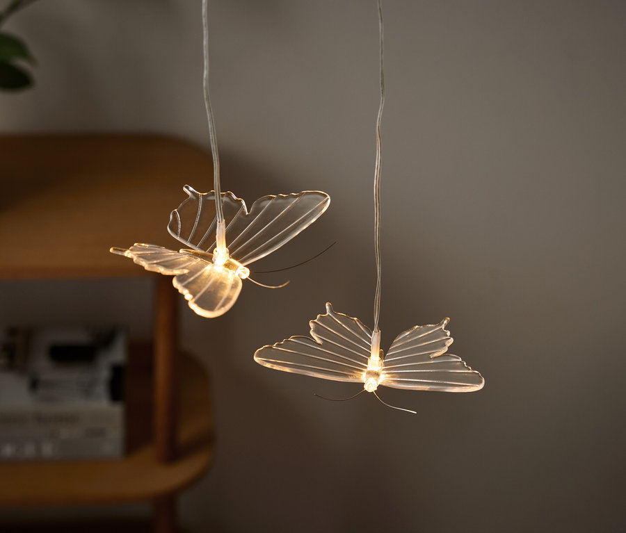 Dve svetlá v tvare motýľov visia zo stropu.